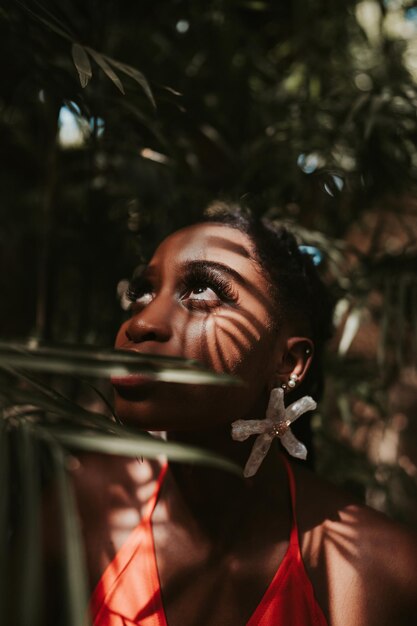 Foto disparo de enfoque superficial de una atractiva mujer afroamericana con rastas posando en la cámara