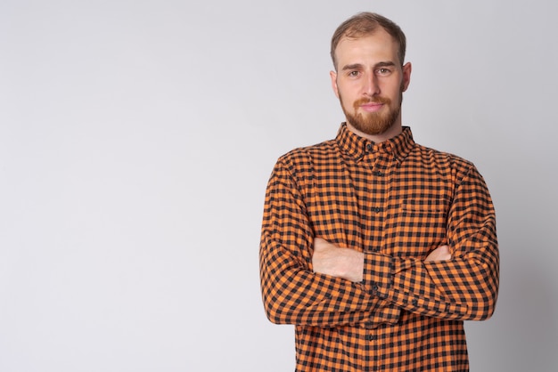 Disparo de estudio de hombre joven hipster barbudo contra un blanco