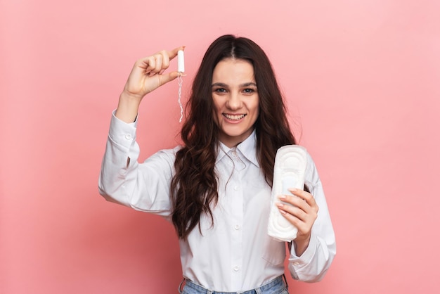 Disparo de estudio de una niña sosteniendo un protector de panty y tampones para la menstruación ... El concepto de higiene femenina.