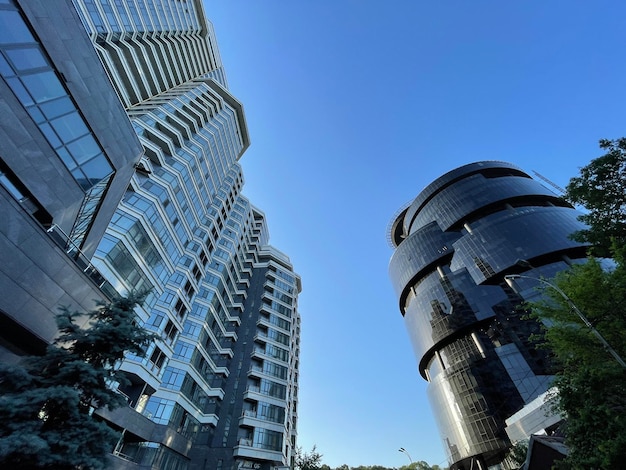 Disparo de gran angular bajo de un rascacielos de cristal negro y moderno edificio de apartamentos en la ciudad