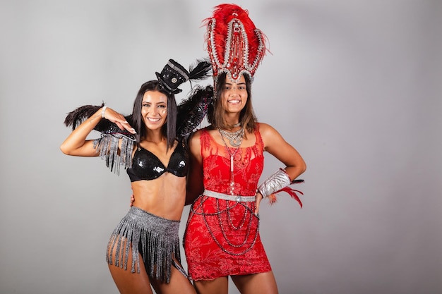 Disparo horizontal de medio cuerpo de dos amigos brasileños en trajes de carnaval posando para la foto