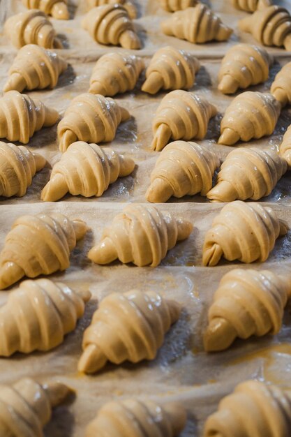 Disparo de muchos croissants seguidos ya manchados con huevo en una panadería