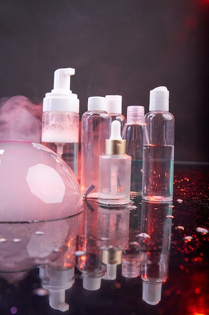 Disparo vertical de botellas de cosméticos transparentes concepto de publicidad de cosméticos burbuja rosa y vapor