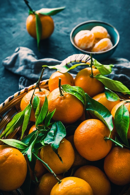 Disparo vertical de frutos de naranja mandarina sobre un fondo oscuro