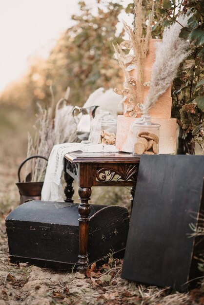 Foto disparo vertical de un gran pastel con decoraciones en la mesa de madera al aire libre