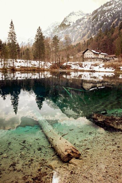 Disparo vertical de una pequeña casa y el hermoso lago transparente en Christlesee Baviera Alemania