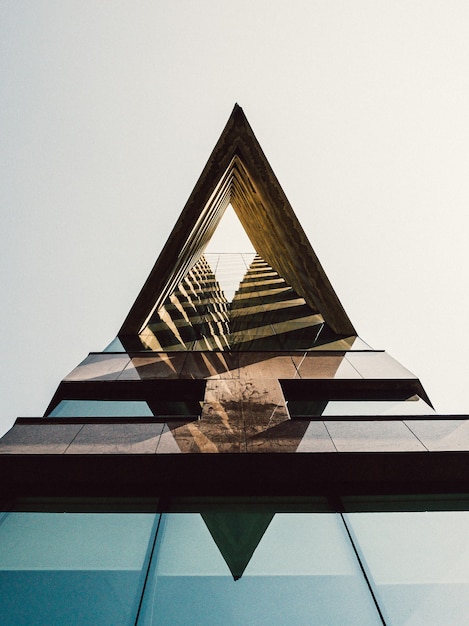 Disparo vertical de un rascacielos de cristal con una arquitectura moderna contra el cielo azul