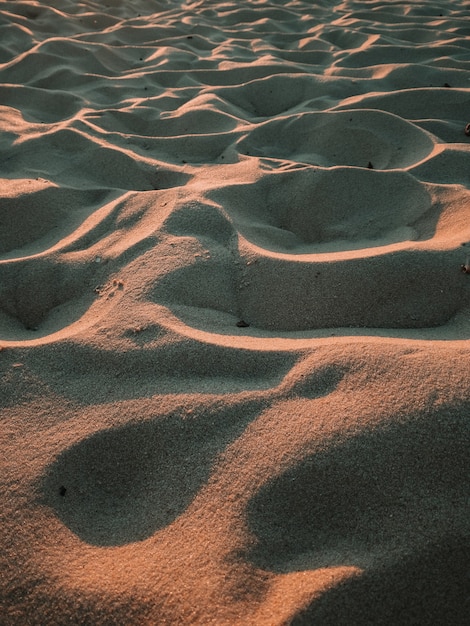 Disparo vertical de textura de arena en modo ola en la costa del mar