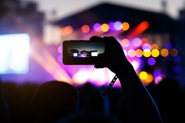 Disparos en el concierto del festival de teléfonos inteligentes fondo de bokeh de escenario de música borrosa para el diseño