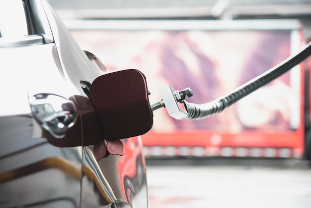 Foto dispensador de cabeça de veículo de gás natural ngv com um carro no posto de gasolina na tailândia