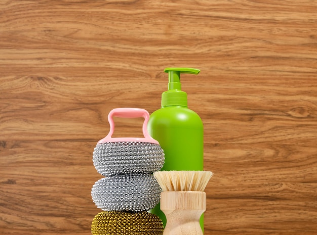 Dispensador de detergente verde e várias esponjas abrasivas para limpeza e lavagem de pratos Trabalho de cozinha