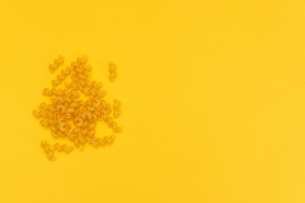 Una dispersión de pasta sobre un fondo amarillo.
