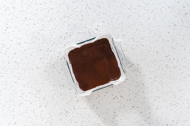 Disposição plana Despejar a mistura de fudge na assadeira forrada com papel manteiga para preparar o fudge simples