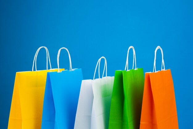 Disposición de bolsas de la compra sobre fondo azul.