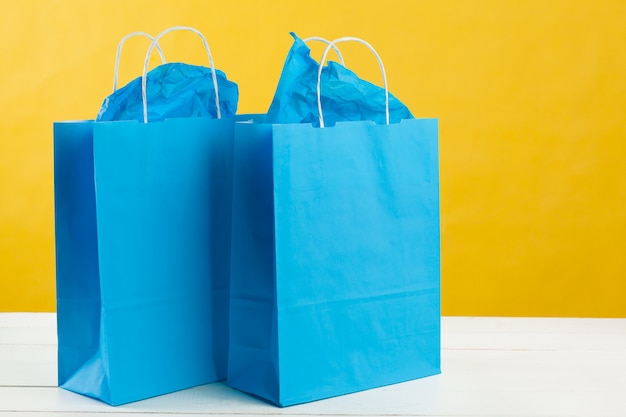 Foto disposición de bolsas de compras sobre fondo amarillo brillante