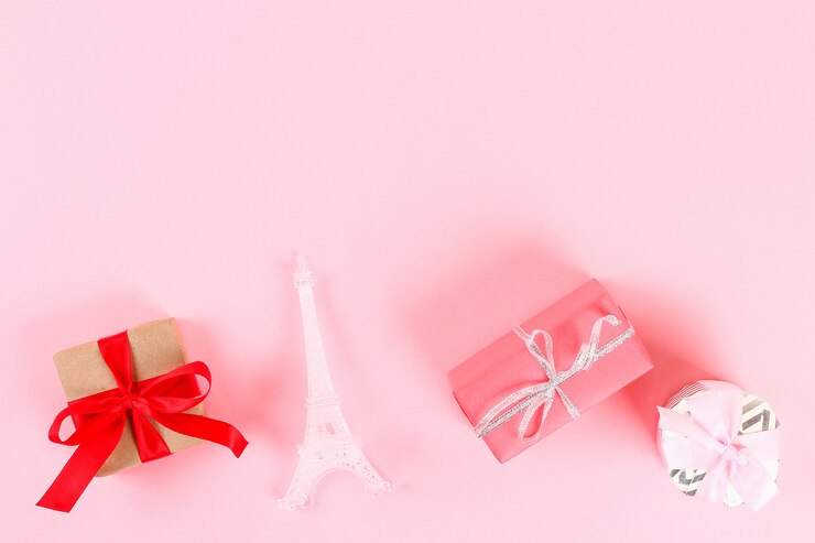 Foto disposición del día de san valentín. regalos, corazones, torre eiffel sobre un fondo rosa pastel. día de san valentín