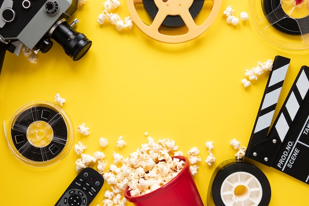 Disposición plana de elementos cinematográficos sobre un fondo amarillo con espacio de copia
