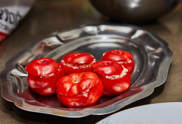 Disposición de tomates rellenos con hojas de menta frescas en una bandeja de metal en la cocina