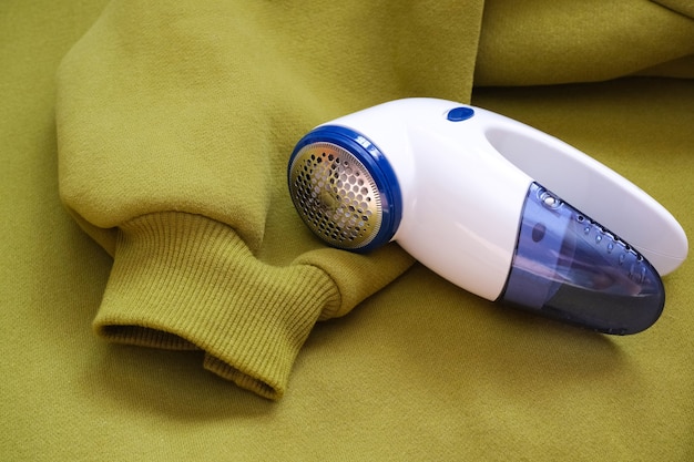 Dispositivo elétrico para remoção de pelos e penugens em textura de tecido. Máquina de barbear para lã. A máquina para retirar pellets no fundo de uma camisola de malha.