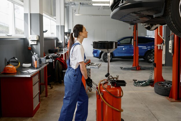 Foto dispositivo de empuje mecánico femenino para la recepción de aceite de motor de automóviles usados equipamiento profesional portátil de drenaje y extracción neumático de aceite residual en el servicio de automóviles