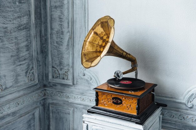 Foto dispositivo musical gramófono antiguo con placa o disco de vinilo en caja de madera jugador de discos de latón antico gramógrafo con altavoz de cuerno concepto de entretenimiento retro