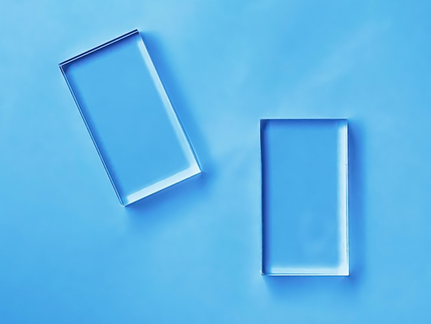 Dispositivo de vidrio sobre fondo azul tecnología futura y diseño de maqueta de pantalla abstracta