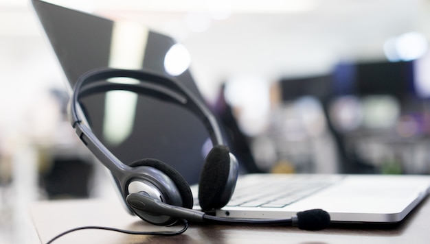 Foto dispositivos de fone de ouvido na mesa de escritório para o conceito de suporte de serviço ao cliente