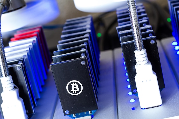 Dispositivos USB de mineração Bitcoin em uma fileira com pequenos ventiladores.