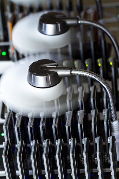 Dispositivos USB de minería de Bitcoin en una fila con pequeños ventiladores.