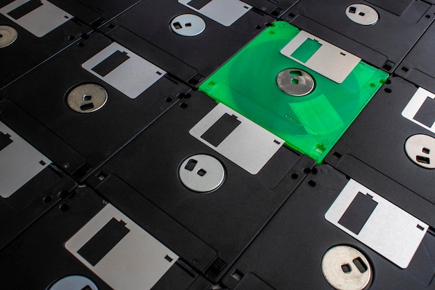 Foto un disquete verde se encuentra en una pila de disquetes viejos