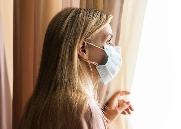 Foto distanciamento social de mulher loira em casa devido a pandemia