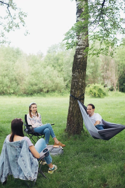 Distanciamiento social Pequeño grupo de personas que disfrutan de una conversación en un picnic con distancia social en el parque de verano Actividad de ocio juntos en nuevas reuniones normales siguiendo protocolos de seguridad
