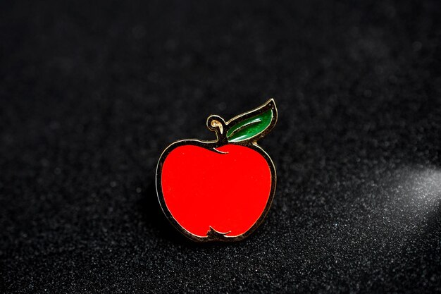 Distintivo de alfinete de maçã vermelha na imagem de fundo preto