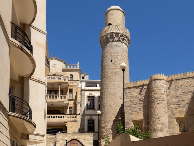 Distrito de la ciudad vieja con minarete antiguo y edificios modernos juntos Bakú Azerbaiyán