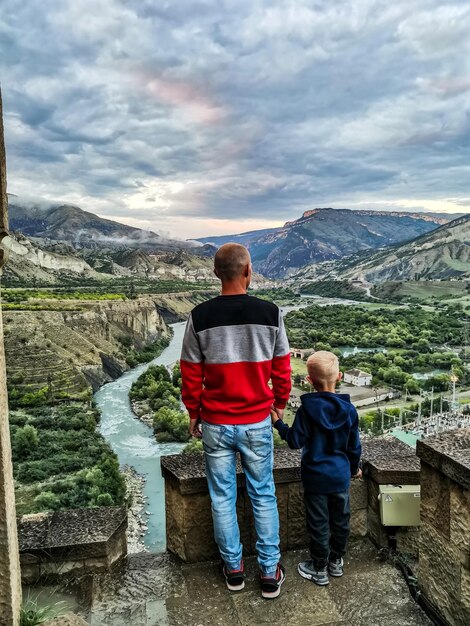 DISTRITO DE GUNIBSKY RUSIA JUNIO 2021 Un hombre con un niño en la Torre Andalal en la HPP Gunibskaya Daguestán