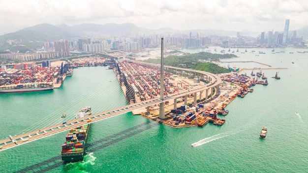 Distrito industrial portuário de hong kong com navio porta-contentores de carga e ponte de stonecutters.