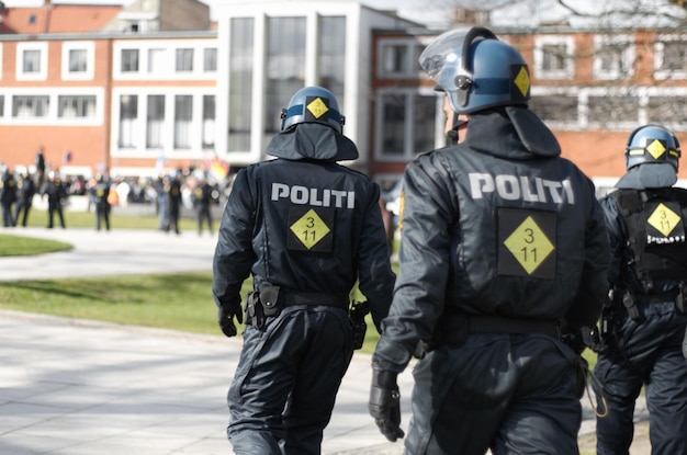 Disturbios policiales y protestas con oficiales de policía en la ciudad por protección o seguridad Uniforme valiente y gobierno con un grupo de policías en la calle para protestar por los derechos humanos o activistas