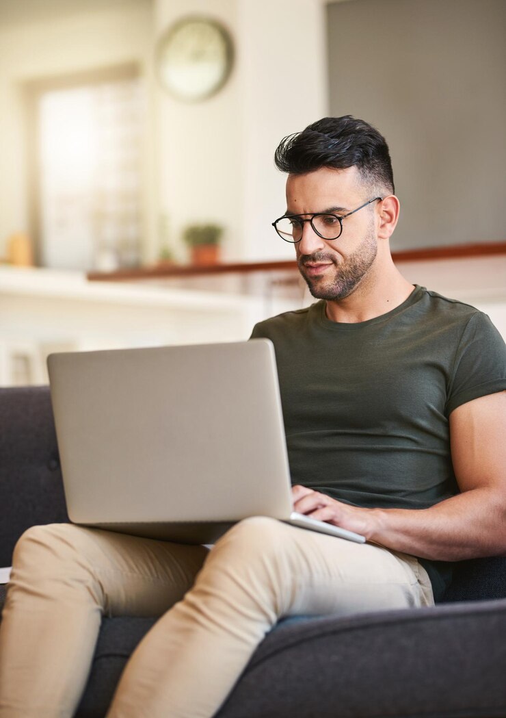 Foto divã de digitação e homem com laptop em casa e pesquisa para edição de vídeo de projeto e mídias sociais na sala de estar criação de conteúdo digital e ocupado na sala de reunião trabalho criativo e remoto em casa