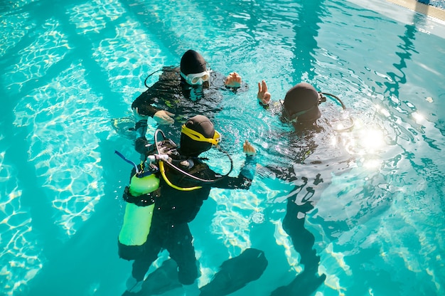 Divemaster y buceadores en aqualungs, escuela de buceo