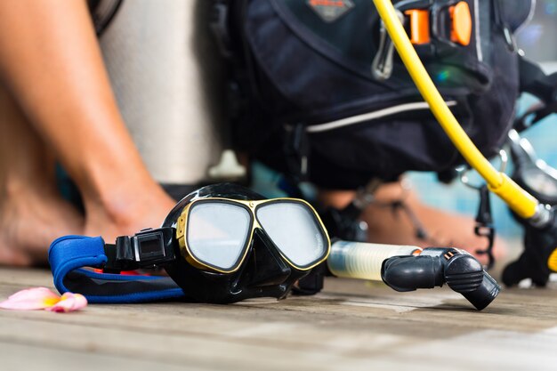 divemaster y estudiantes en el curso de buceo en vacaciones usando un traje de neopreno o buceando en primer plano es un tanque de oxígeno