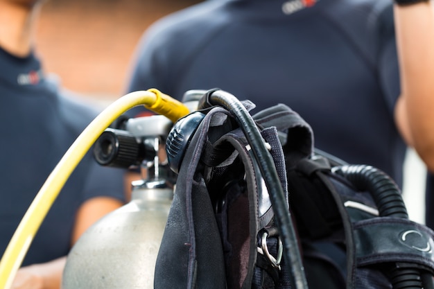 divemaster und studenten am tauchkurs im urlaub im neoprenanzug oder tauchen im vordergrund ist eine sauerstoffflasche