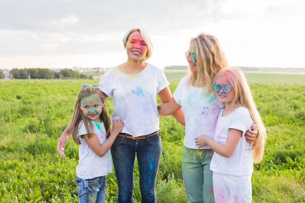 Diversão, cores, feriados indianos e conceito de pessoas - jovens do sexo feminino se divertindo no festival de holi