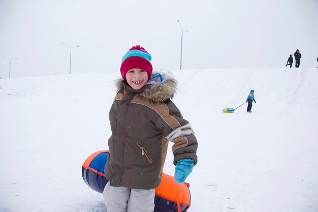 Diversão e jogos de invernoMenino desfrutando de um passeio de trenó