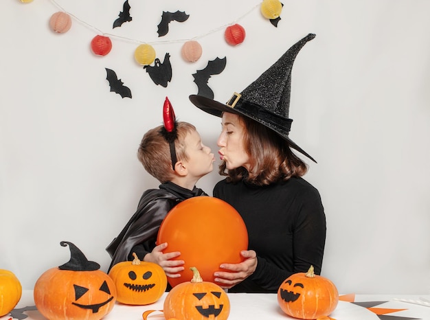 Diversão em família mãe e filho se divertindo e celebrando o halloween em fantasia de bruxa e diabo