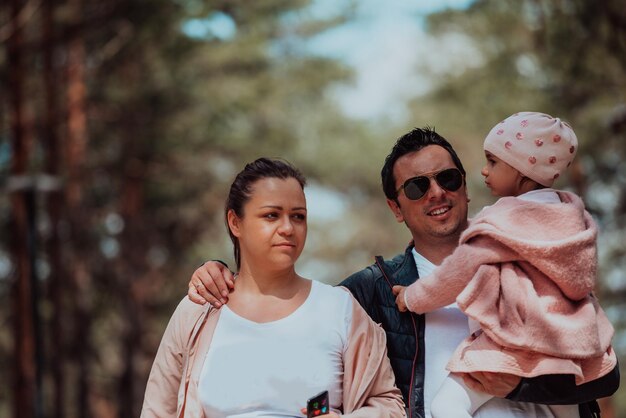 Diversão em família no parque. Família feliz passando tempo no parque e brincando com sua filha.