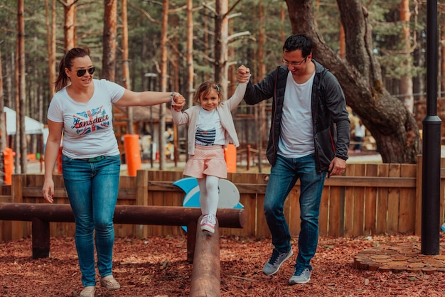 Diversão em família no parque. Família feliz passando tempo no parque e brincando com sua filha.