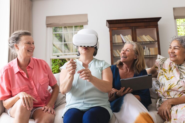 Foto diversas amigas seniores a tentar o fone de ouvido vr em casa a rir-se juntas.