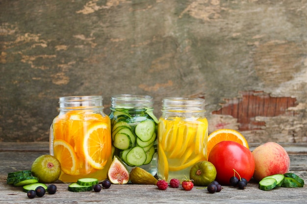 Diversas bebidas, frutas y verduras sobre fondo de madera.