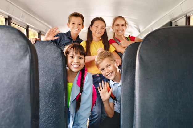 Diversas crianças felizes e alegres se divertindo dentro de um ônibus escolar