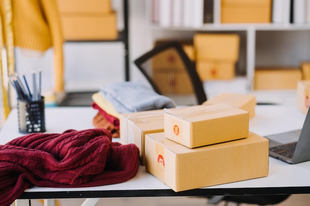 Diversas diseñadoras de moda trabajan con centímetros de sastre en el cuello y sostienen negocios de diseño creativo independientes de tabletas y teléfonos inteligentes en el estudio